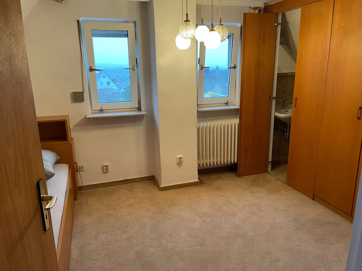 Dachgeschosszimmer mit Einbauschränken und Fenstern
