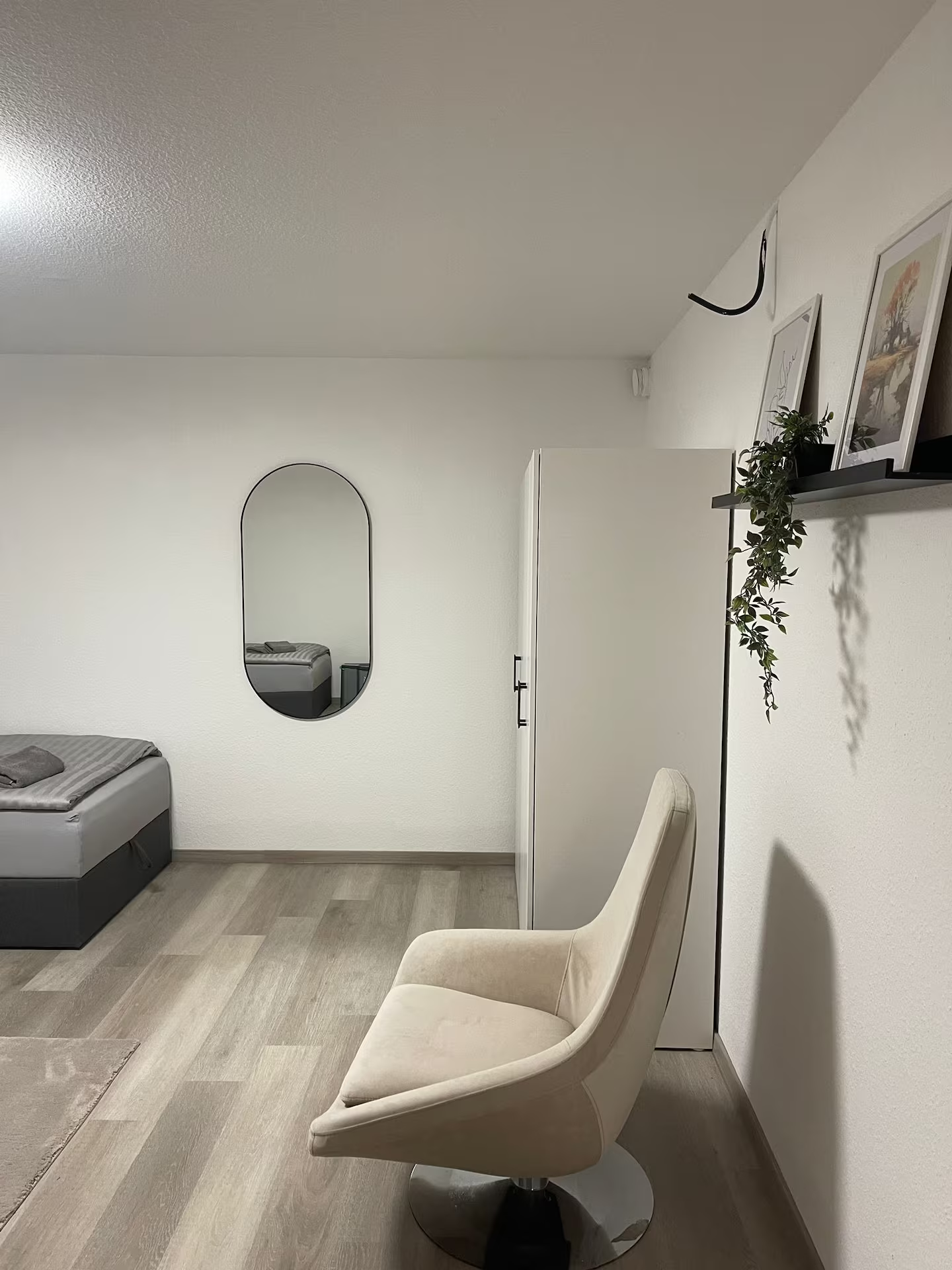 Schlafraum mit Sessel, Spiegel und Einzelbett