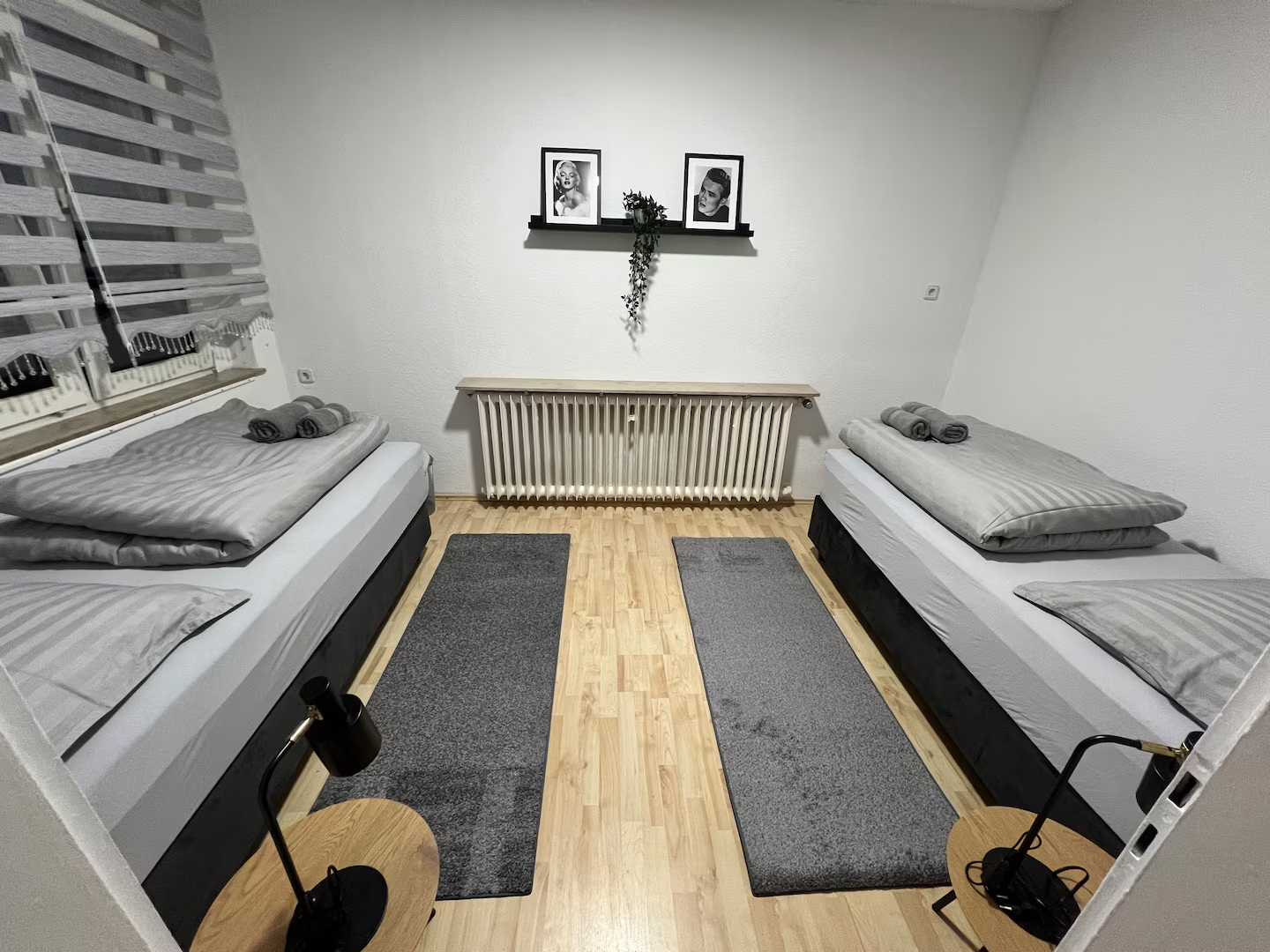Helles Schlafzimmer mit zwei Einzelbetten, Parkett und Leselampen