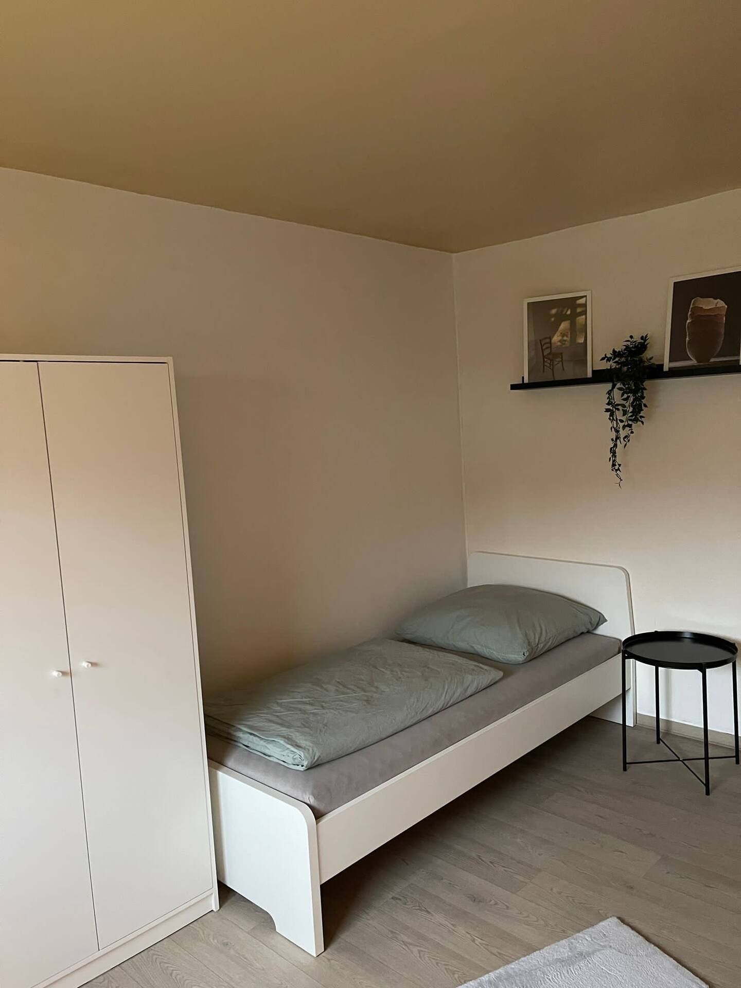 Einzelzimmer mit Lesetisch und Wandregal