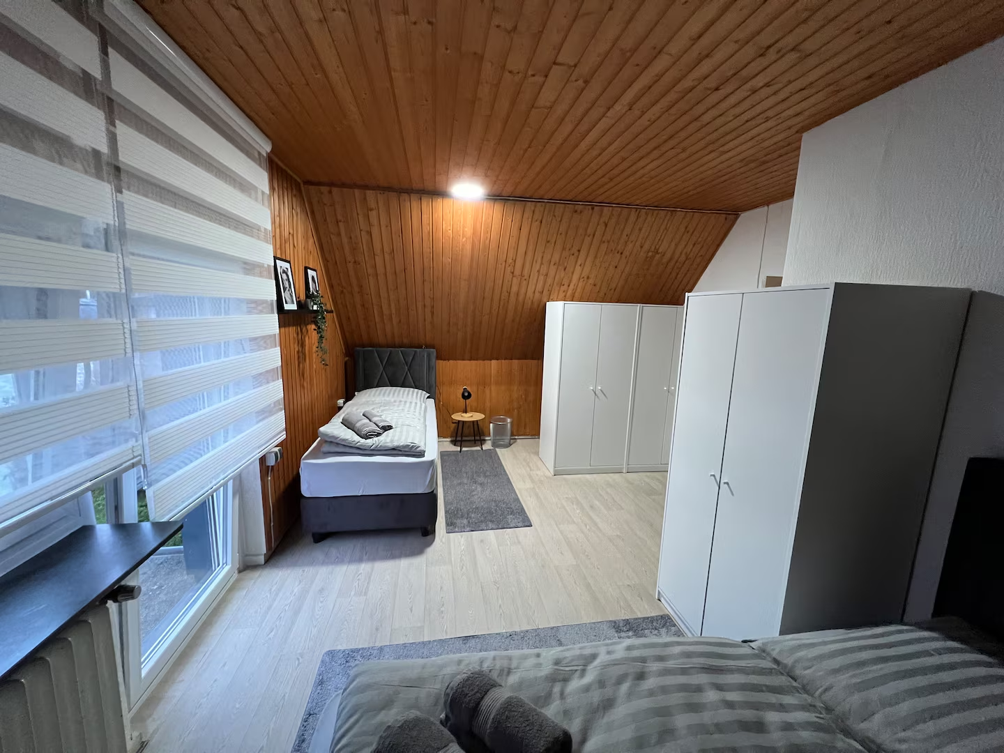Dachgeschosszimmer mit Einzelbett, Kleiderschränken und Fenster