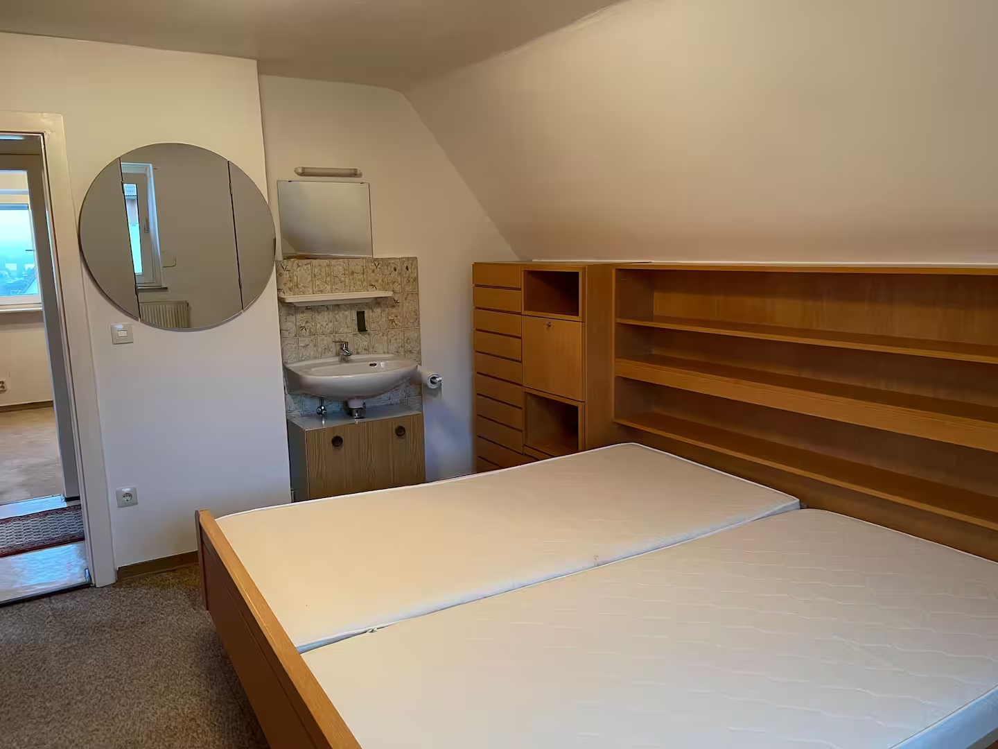 Dachgeschosszimmer mit zwei Schlafplätzen und Waschbecken