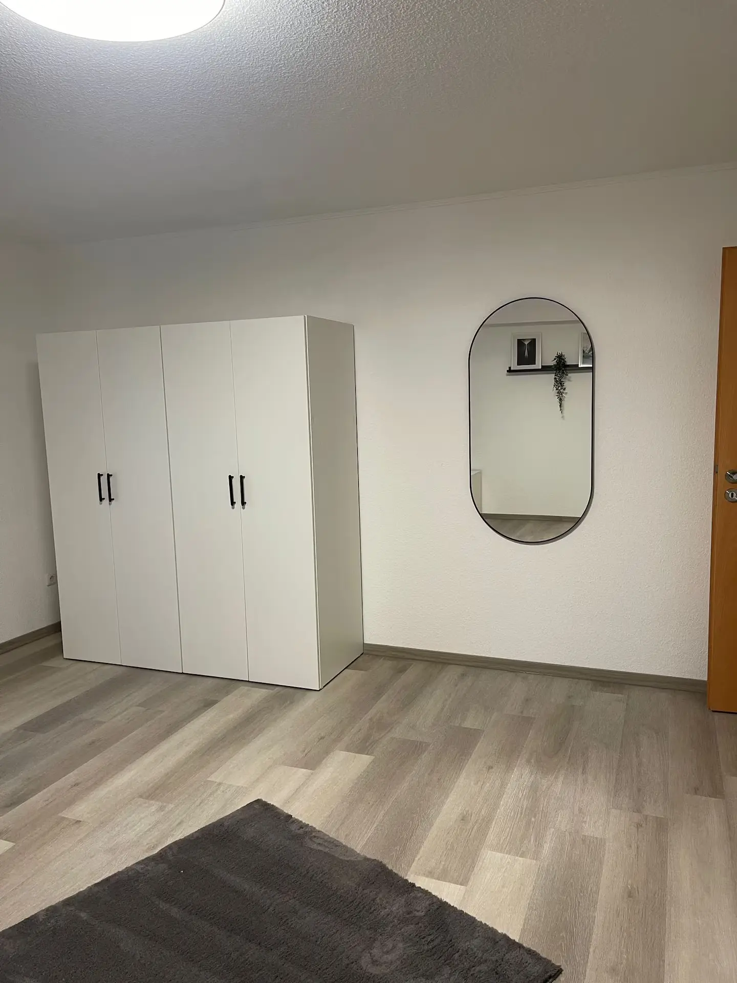 Zimmer mit Kleiderschrank und Wandspiegel