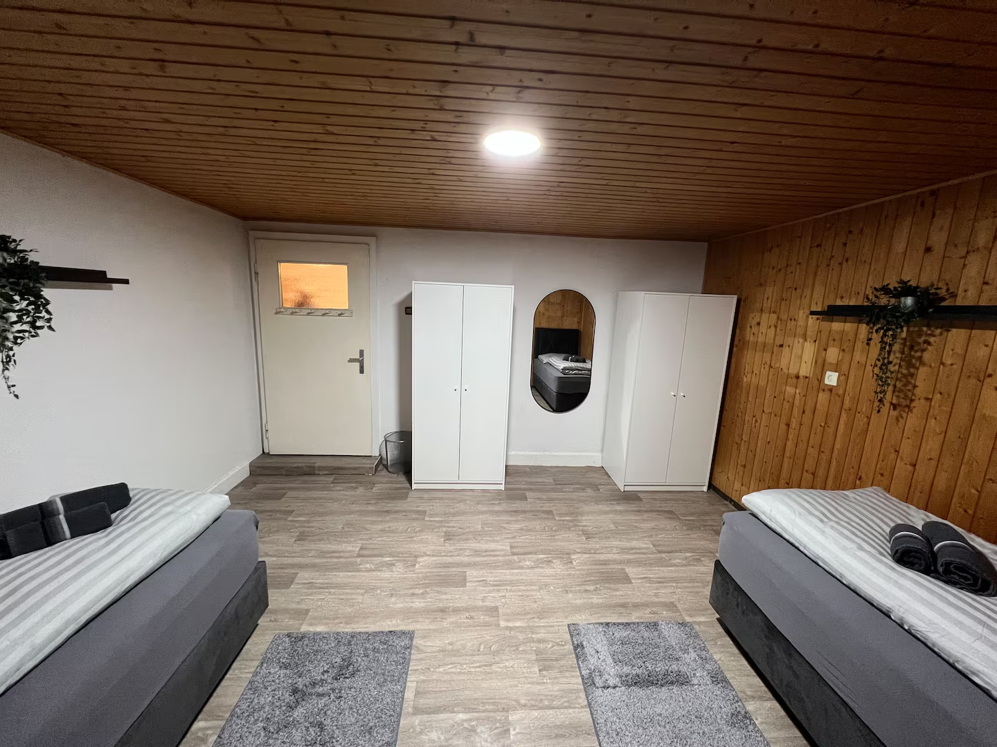 Schlafzimmer mit zwei Einzelbetten, zwei Kleiderschränken und Wandspiegel