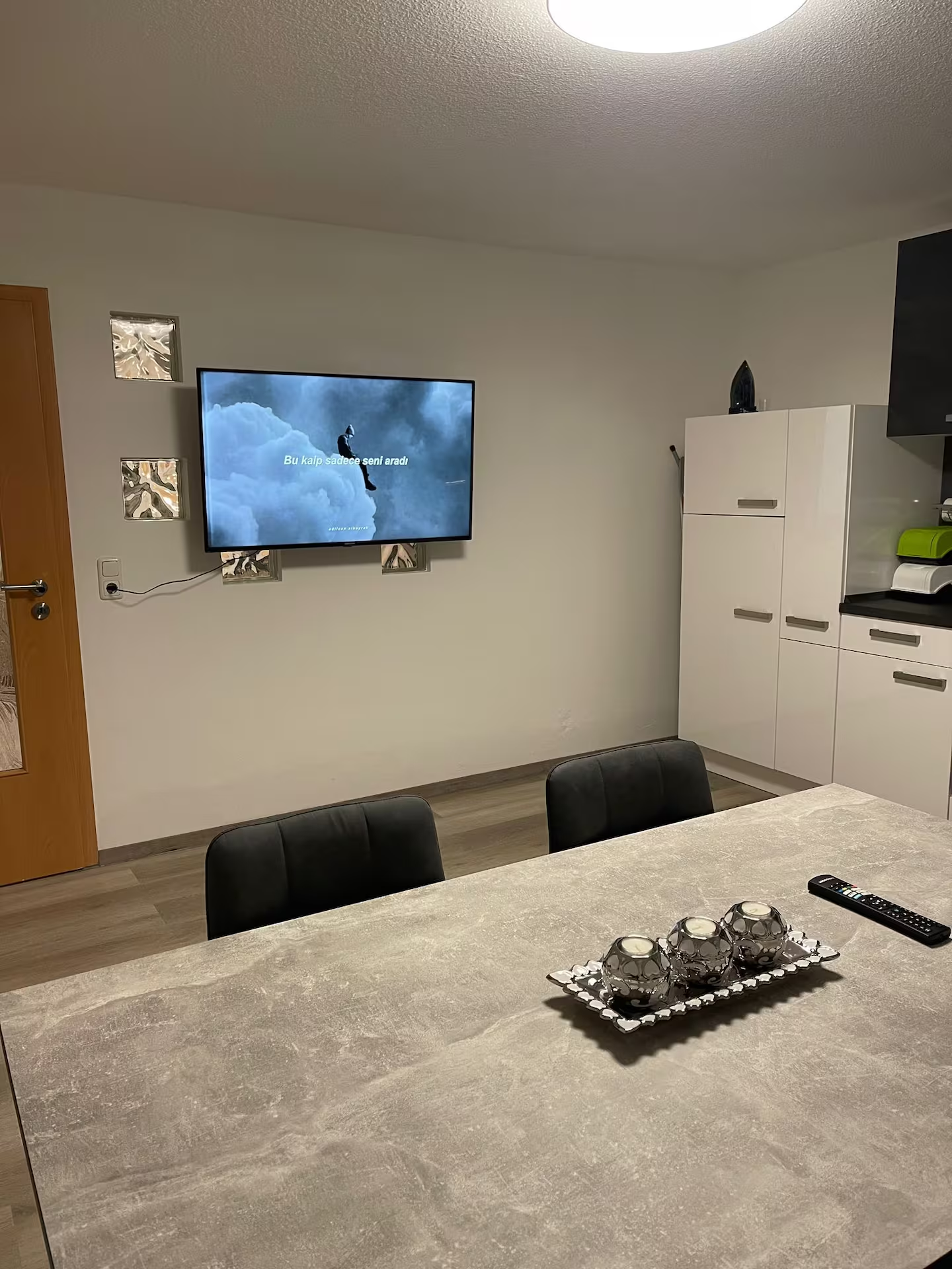 Essbereich mit großem Tisch und Wand-TV